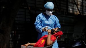 A healthcare worker wearing personal protective equipment (PPE) takes a swab from a migrant laborer for a rapid antigen test at the site of an under construction residential complex amidst a coronavirus disease (COVID-19) outbreak in New Delhi, India, September 19, 2020. Photo: Reuters/Adnan Abidi