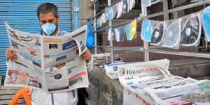 A vendor wearing a protective face mask reads a newspaper at his stall as he sells face masks and newspapers amidst the COVID-19 outbreak in Srinagar, September 7, 2020. Photo: Reuters/Sanna Irshad Mattoo